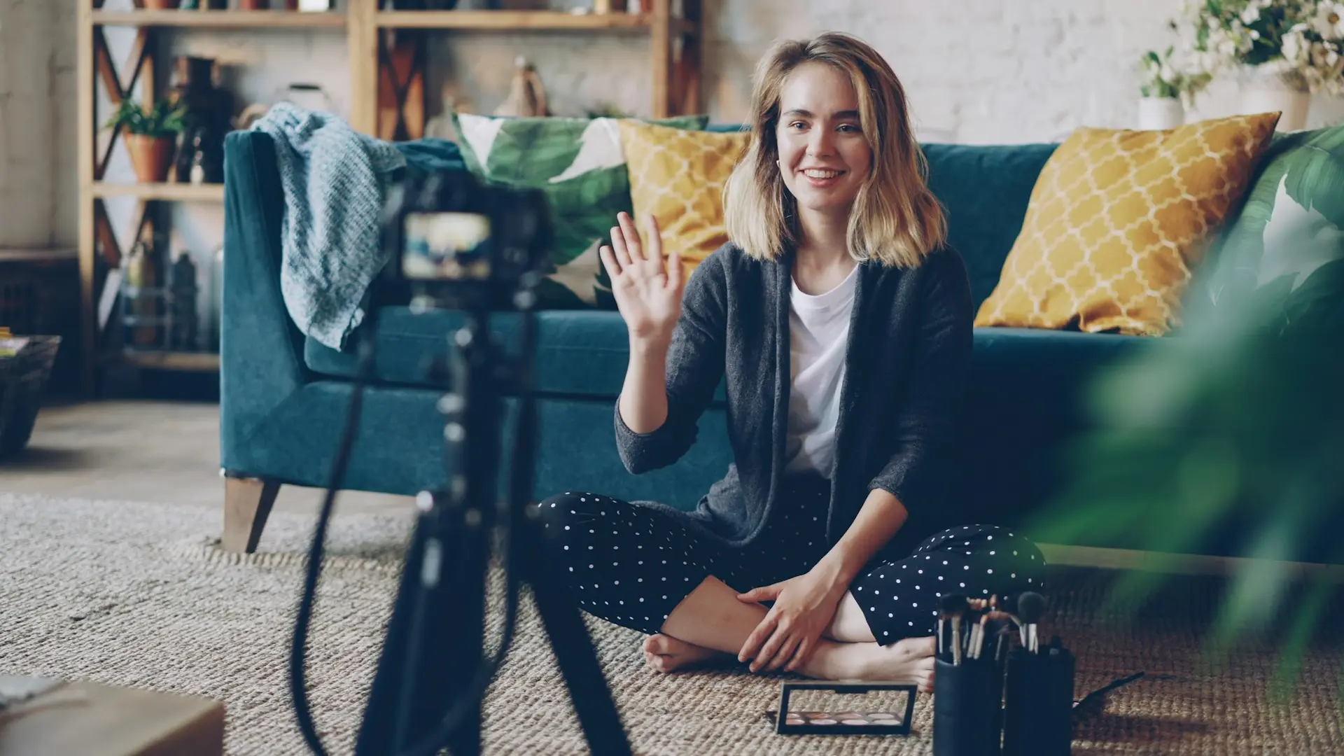 Woman waving hello at camera in living room