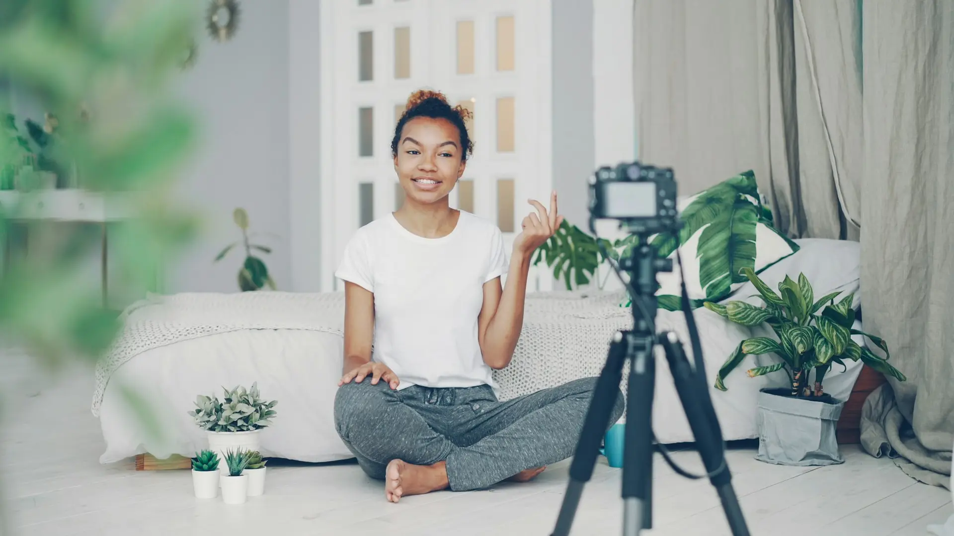 Young woman recording video with a camera in a room