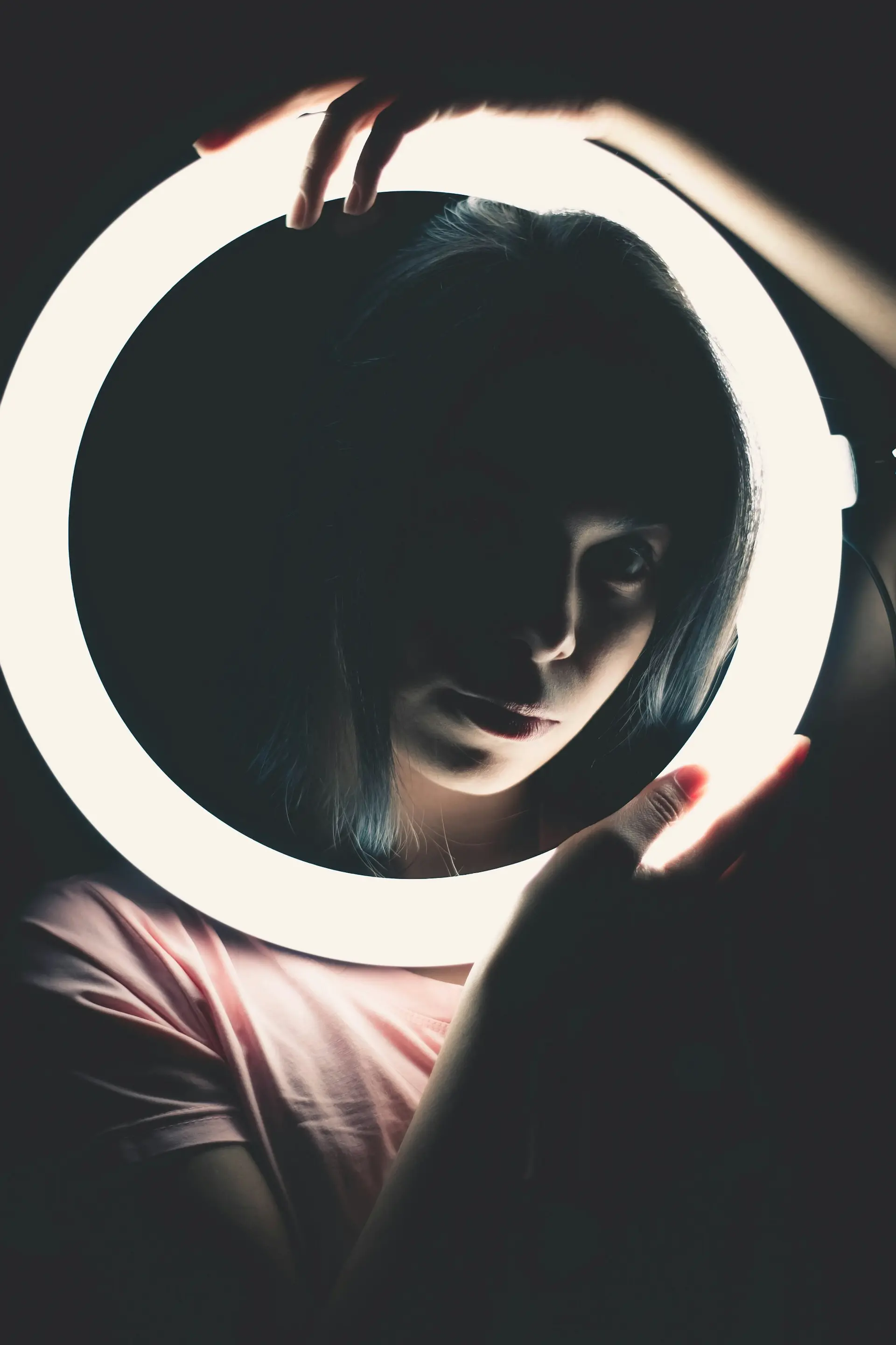 Woman in a red shirt holding a round mirror