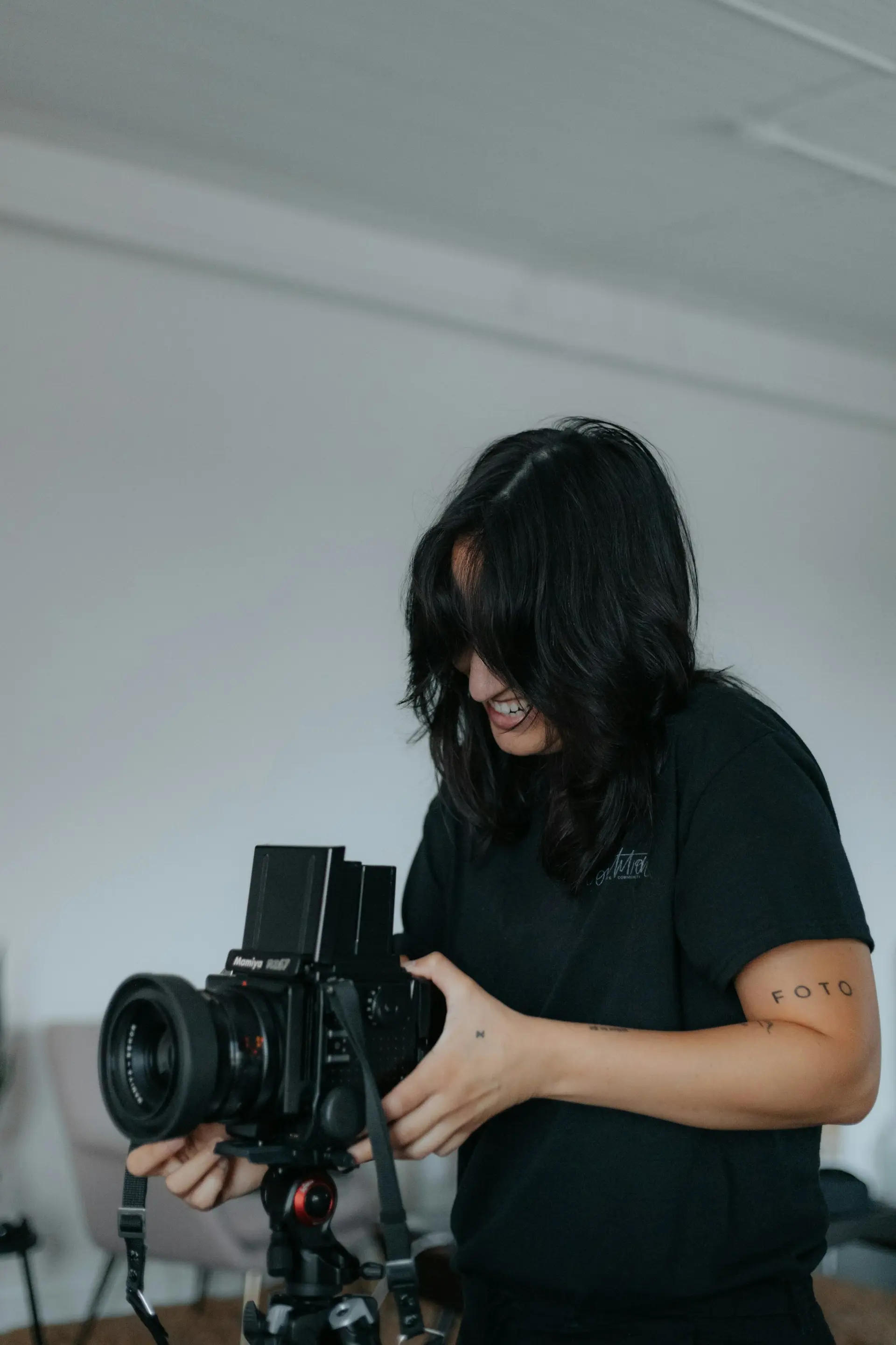 Woman in a black t-shirt holding a camera