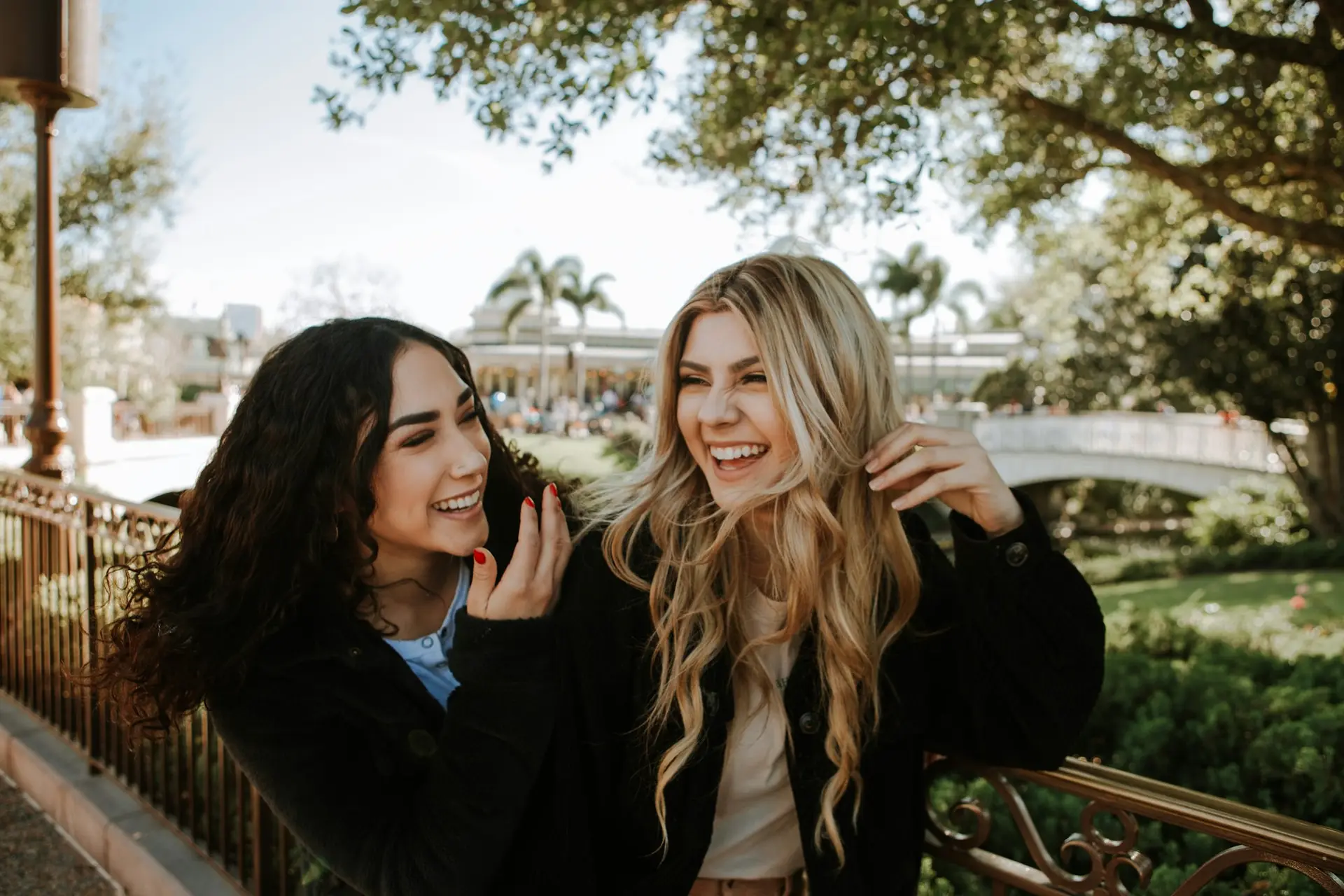 Two women smiling near trees