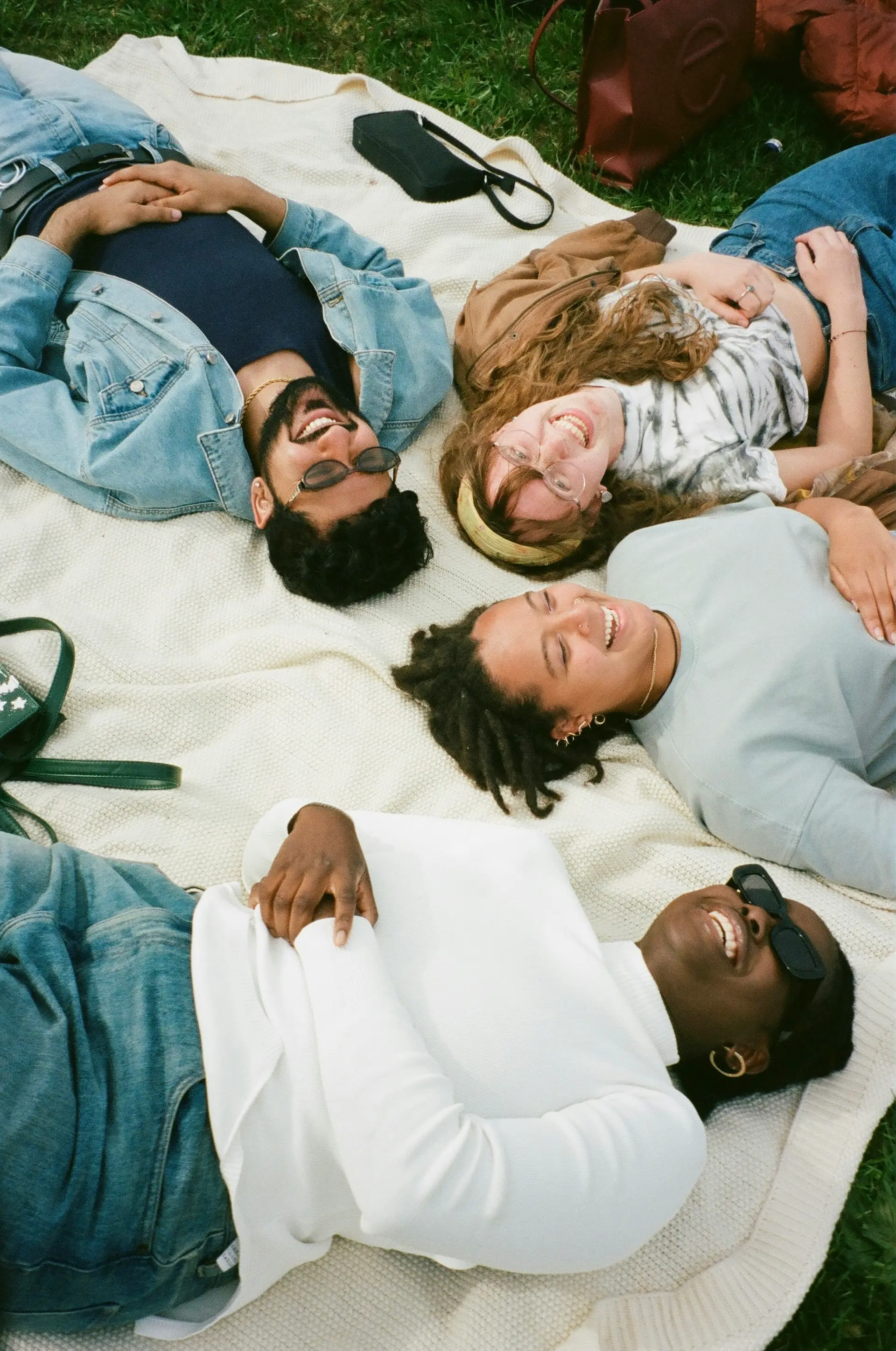 Friends laughing together on a picnic blanket