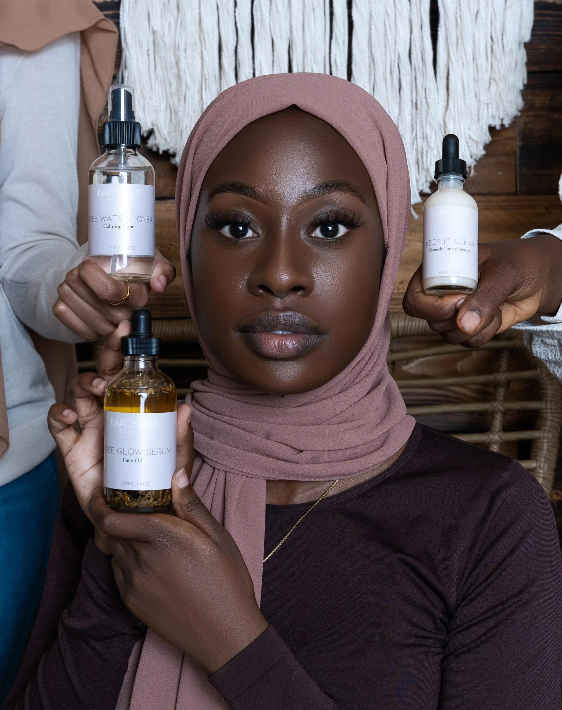 Woman holding oil and lotion bottles